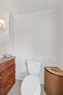 a white toilet sitting next to a bathroom sink and vanity