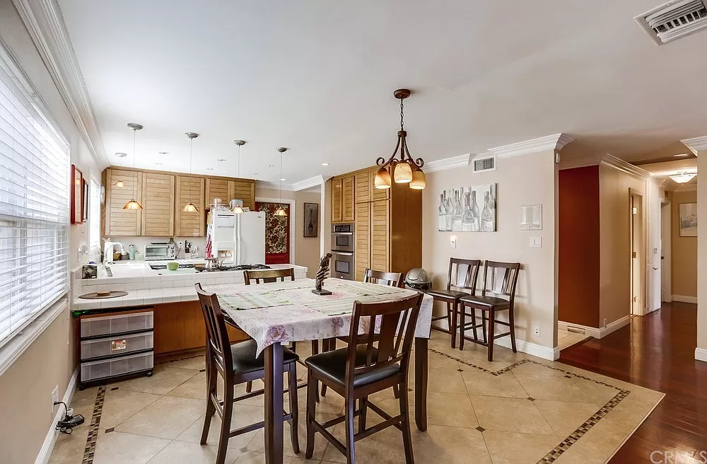 15604 Deblynn Avenue Gardena, CA 90248 - Photo 15 of 22 a view of a dining room and livingroom with furniture wooden floor a chandelier