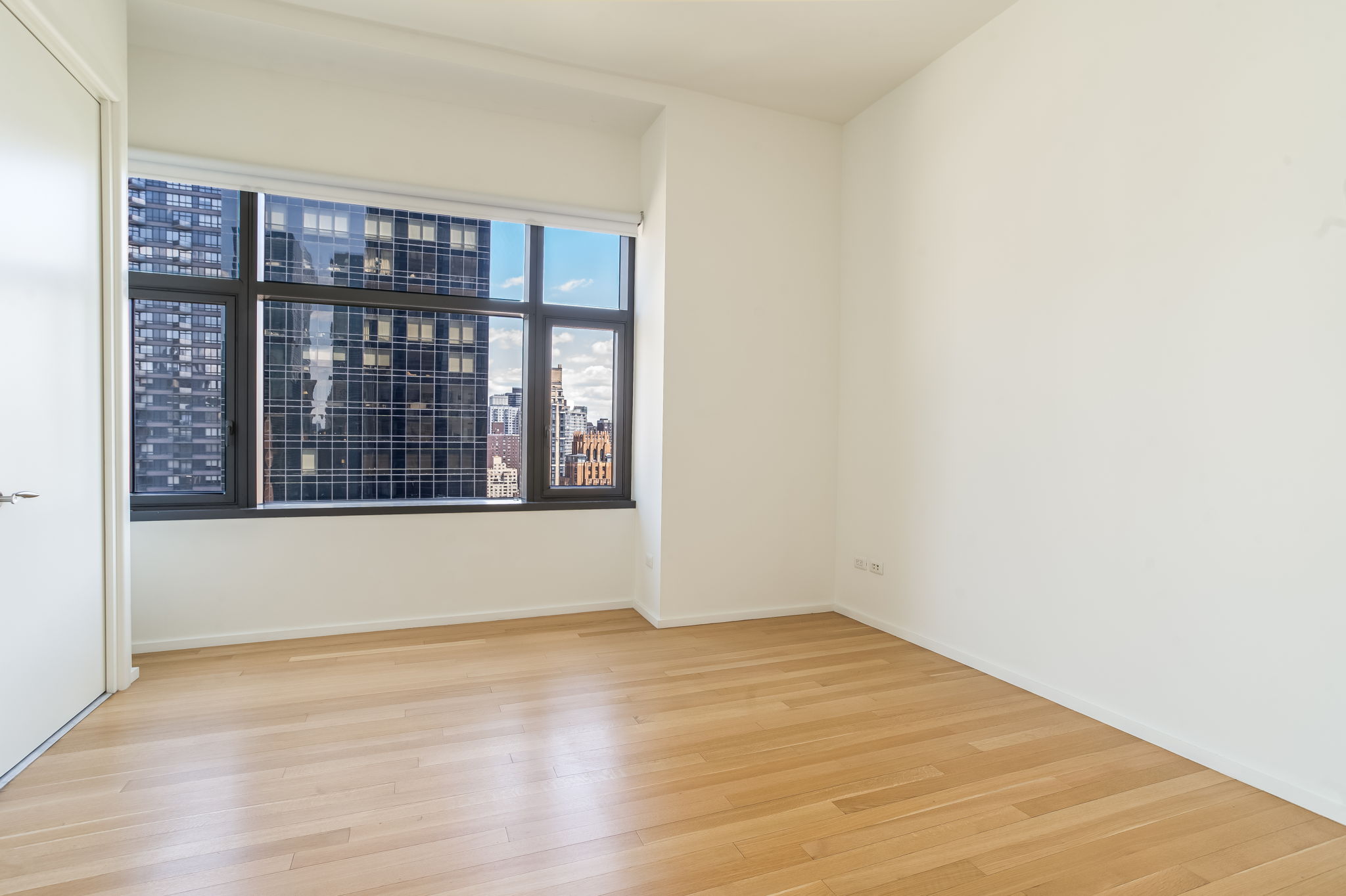 50 United Nations Plaza, Unit 26B Manhattan, NY 10017 - Photo 19 of 25 a view of an empty room with wooden floor and a window