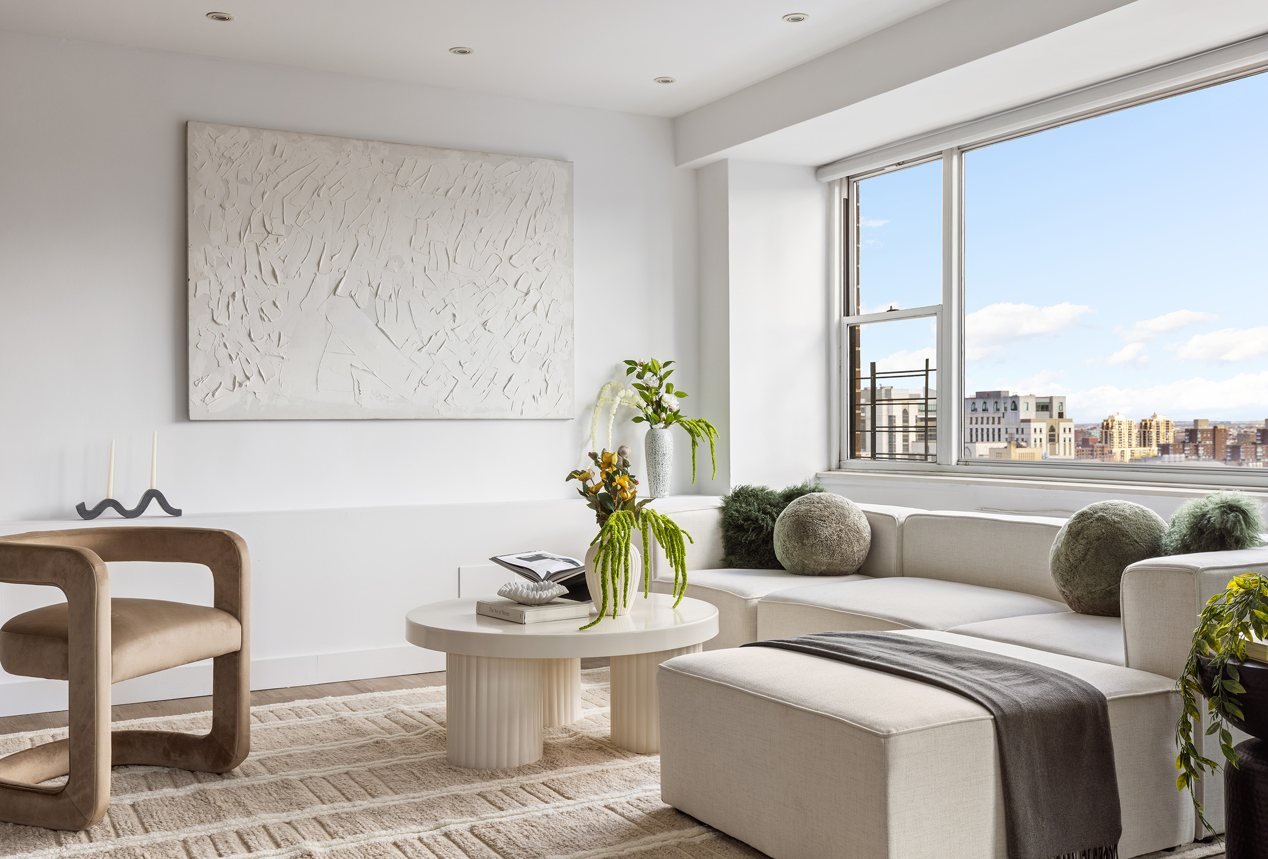 340 East 64th Street, Unit 19L Manhattan, NY 10065 - Photo 2 of 17 a living room with furniture and a large window