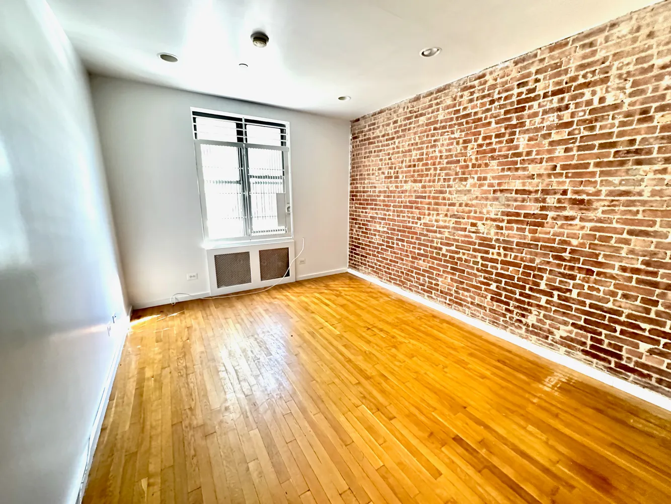 a view of empty room with wooden floor and windows