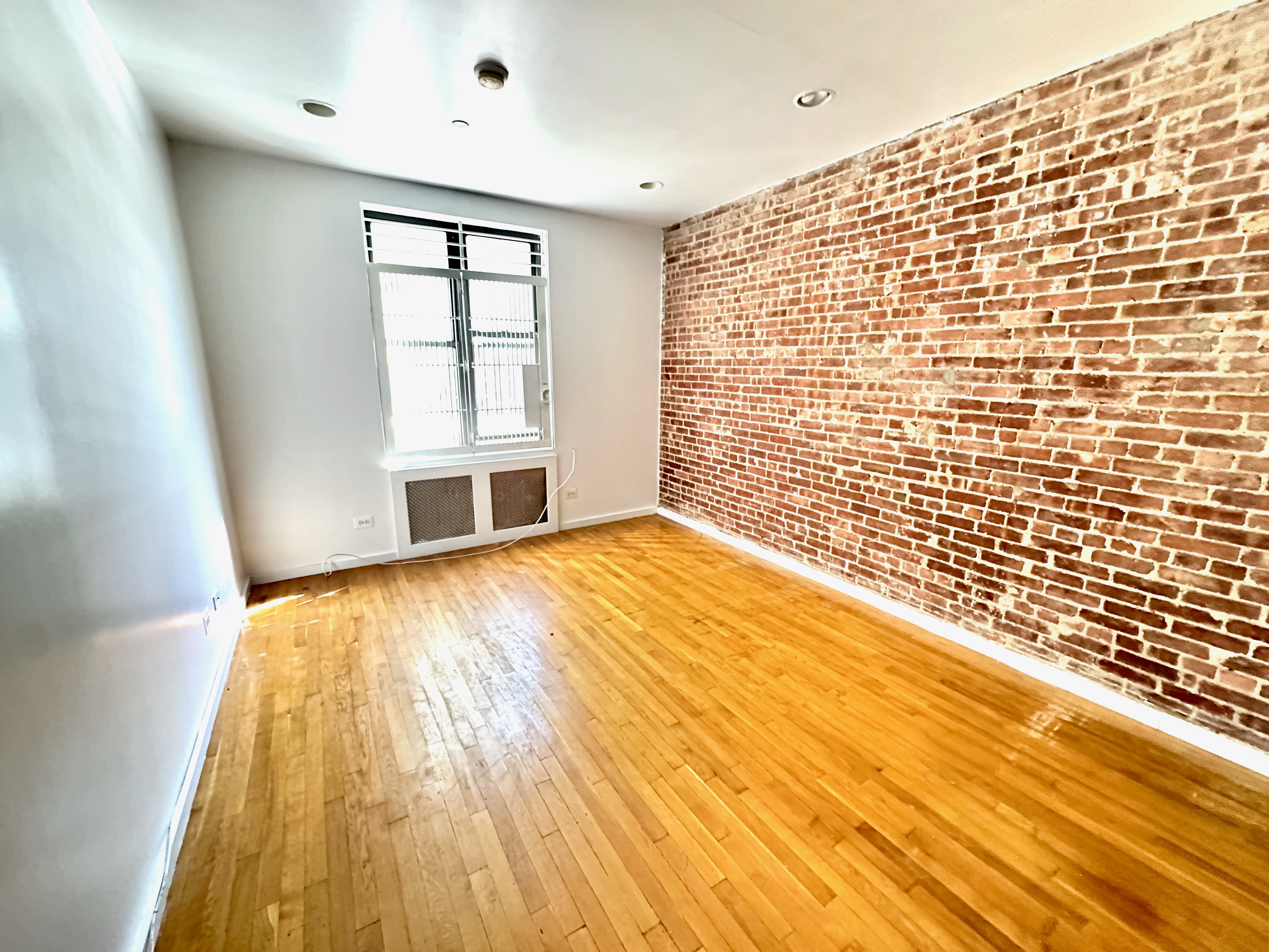 a view of empty room with wooden floor and windows