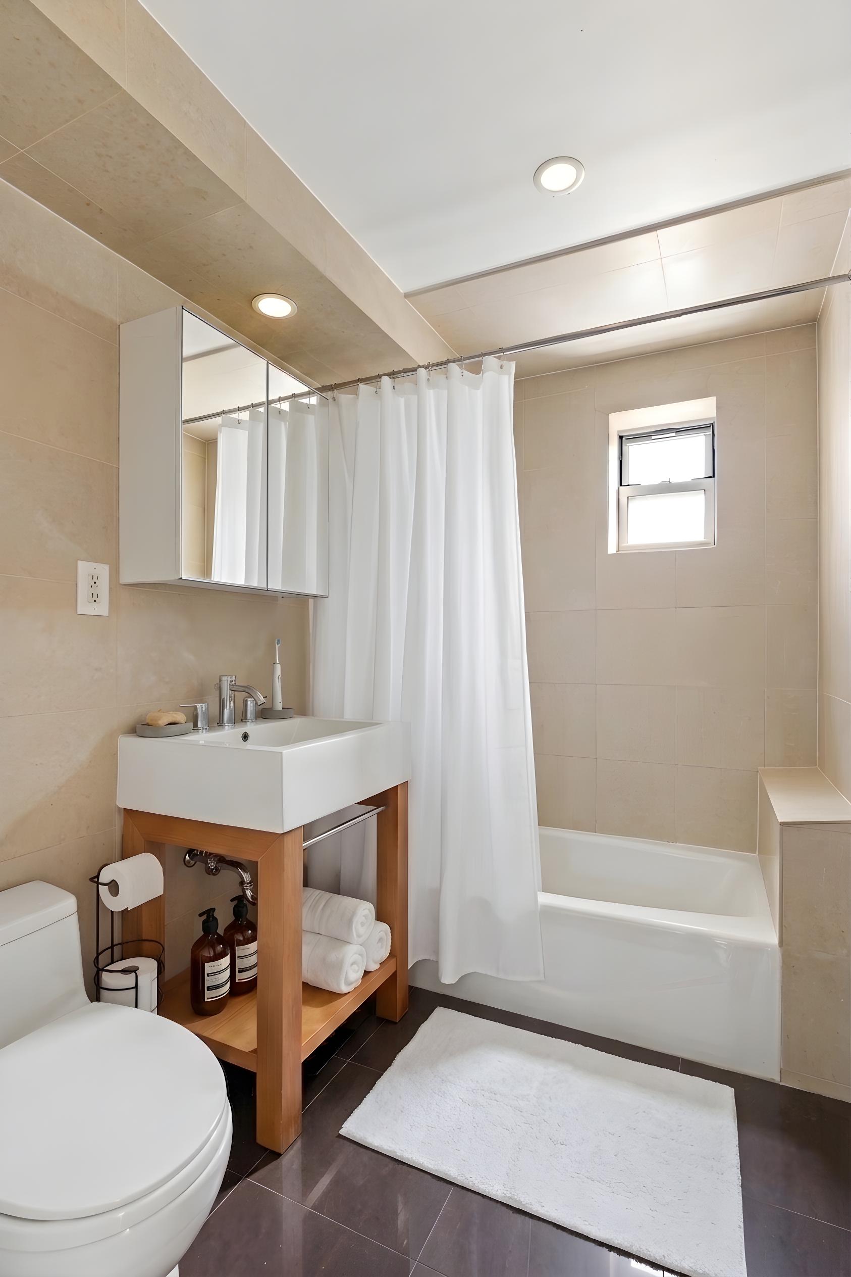 335 Warren Street, Unit 401 Brooklyn, NY 11201 - Photo 5 of 15 a bathroom with a sink a toilet and shower