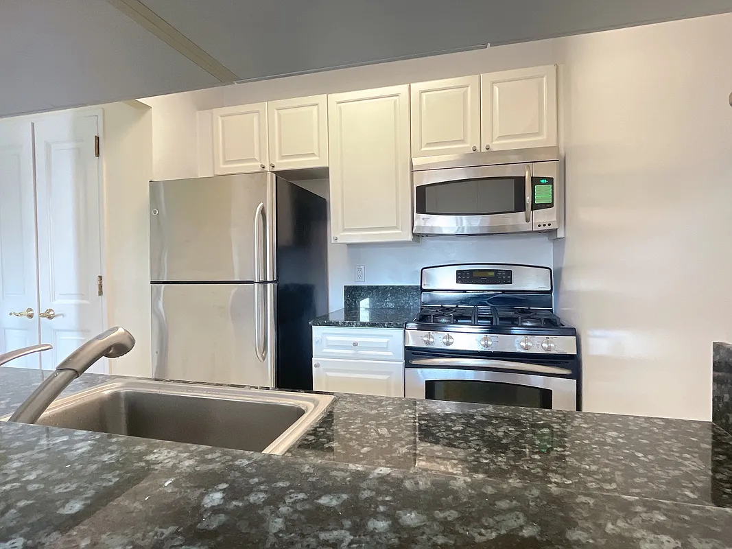400 East 90th Street, Unit 15B Manhattan, NY 10128 - Photo 3 of 15 a kitchen with stainless steel appliances granite countertop a refrigerator and a sink