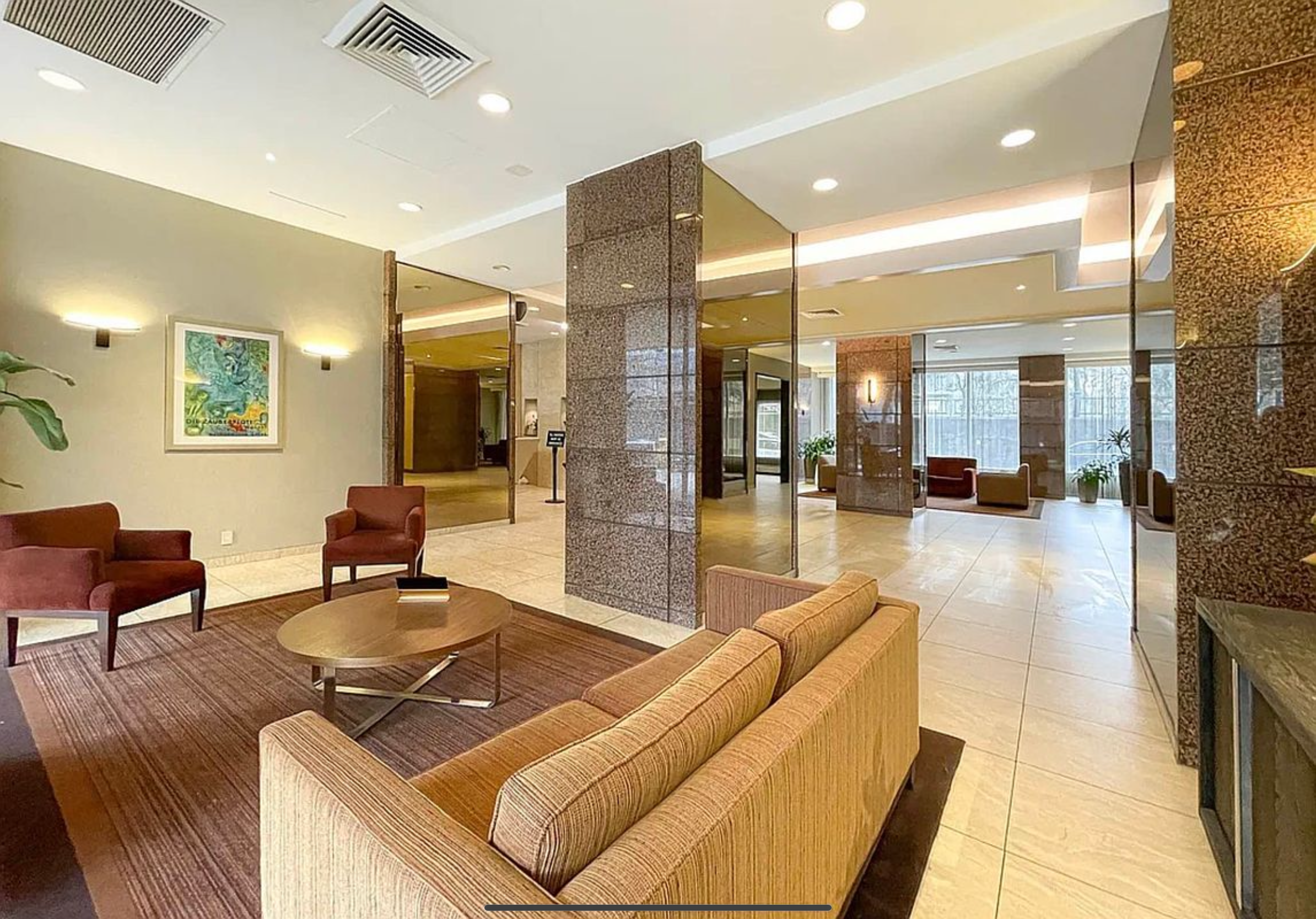 140 West End Avenue, Unit 24D Manhattan, NY 10023 - Photo 9 of 16 a living room with couches a coffee table and kitchen view with wooden floor