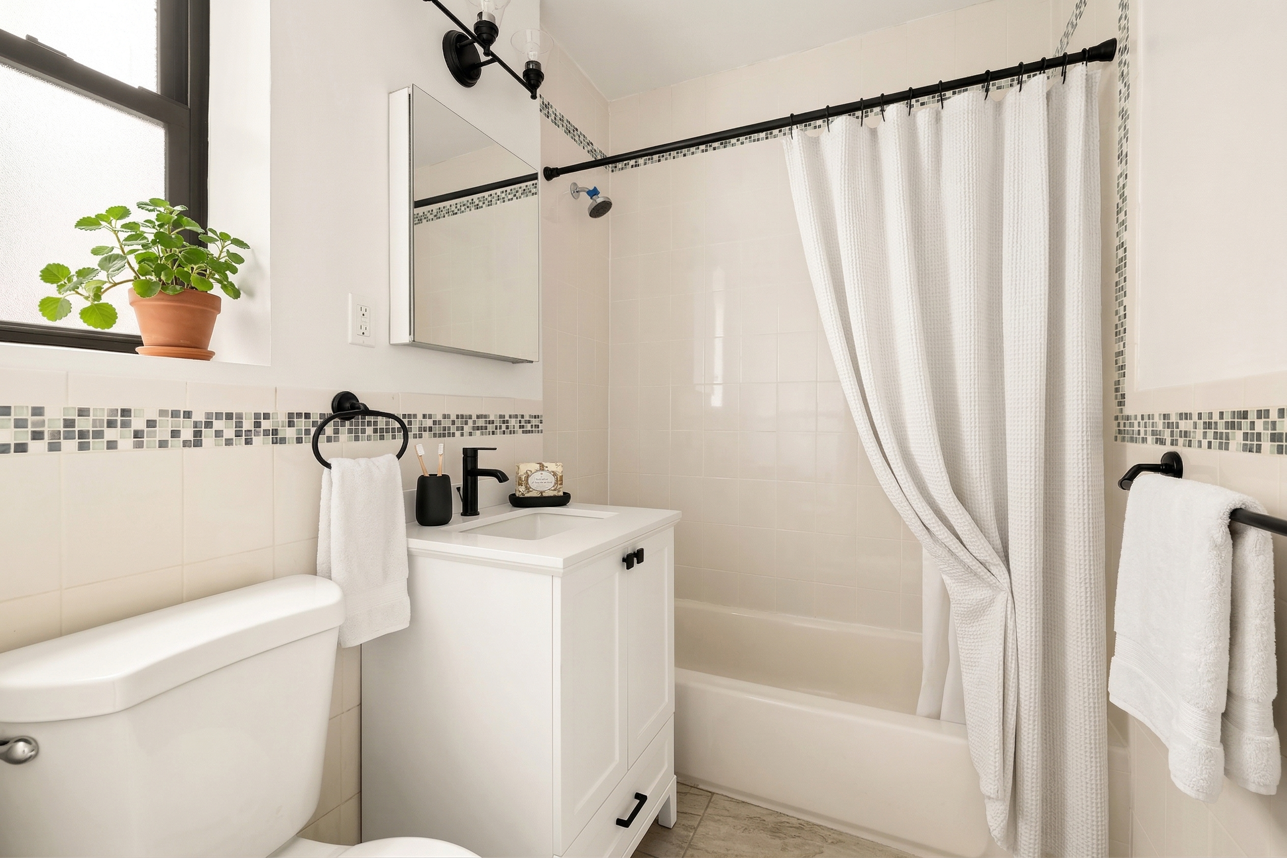 47-39 40th Street, Unit 2G Queens, NY 11104 - Photo 10 of 15 a bathroom with a sink a toilet and a shower