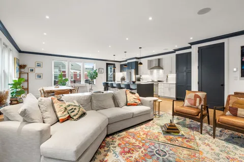 a living room with furniture and view of kitchen