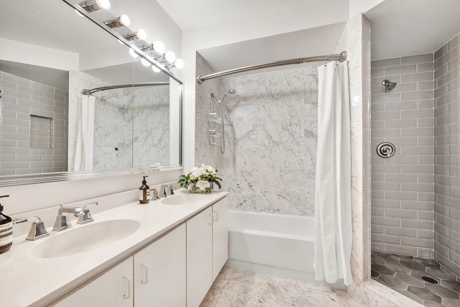 a bathroom with a tub sink shower and a mirror