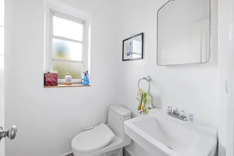 a bathroom with a toilet sink and mirror