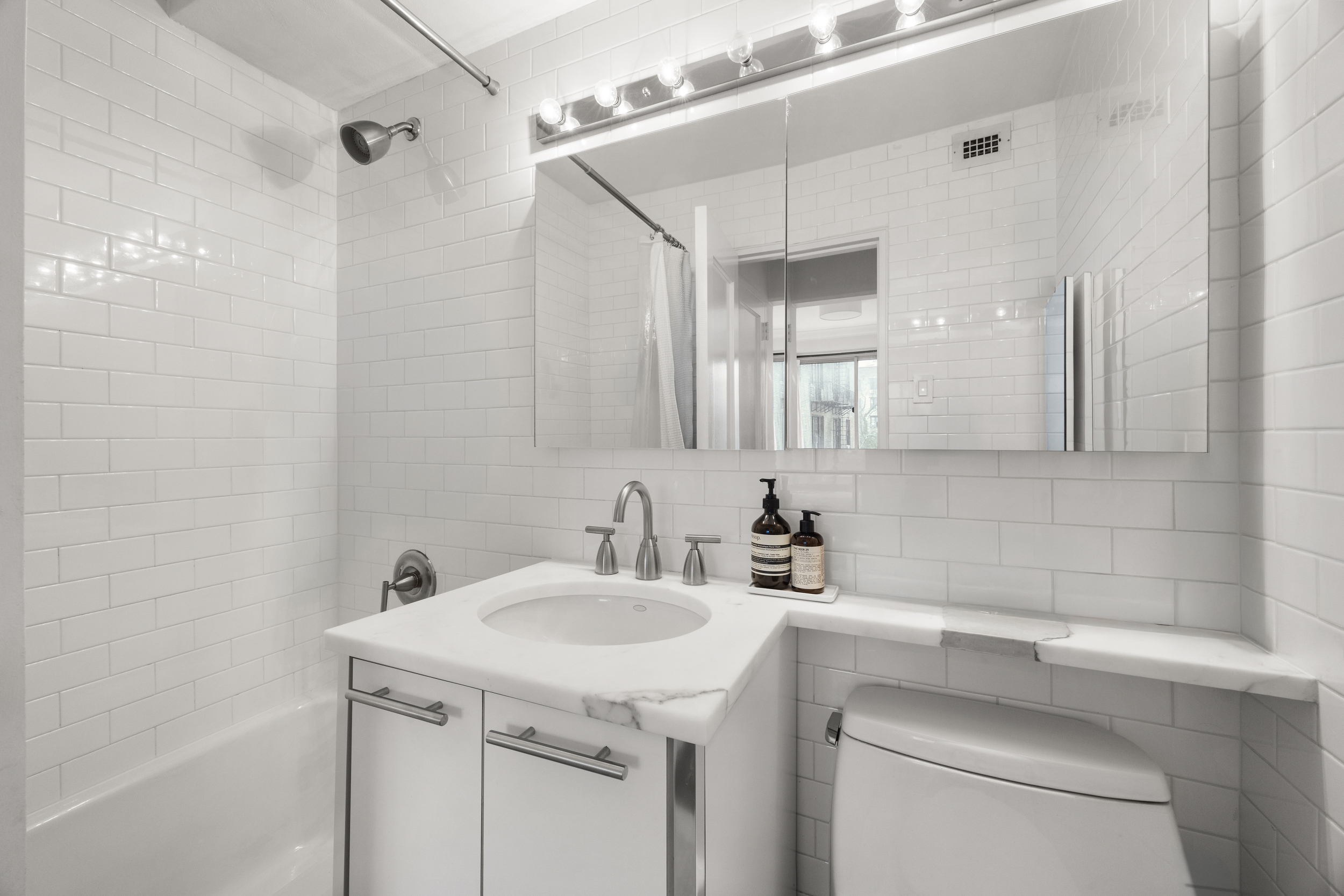 175 West 12th Street, Unit 4L Manhattan, NY 10011 - Photo 10 of 11 a bathroom with a sink and a mirror