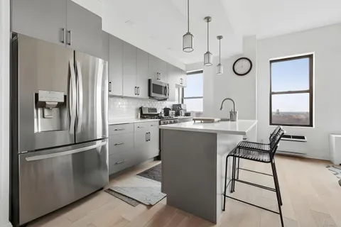 a kitchen with a refrigerator sink and cabinets