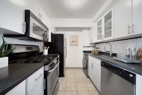 a kitchen with stainless steel appliances a sink stove and cabinets