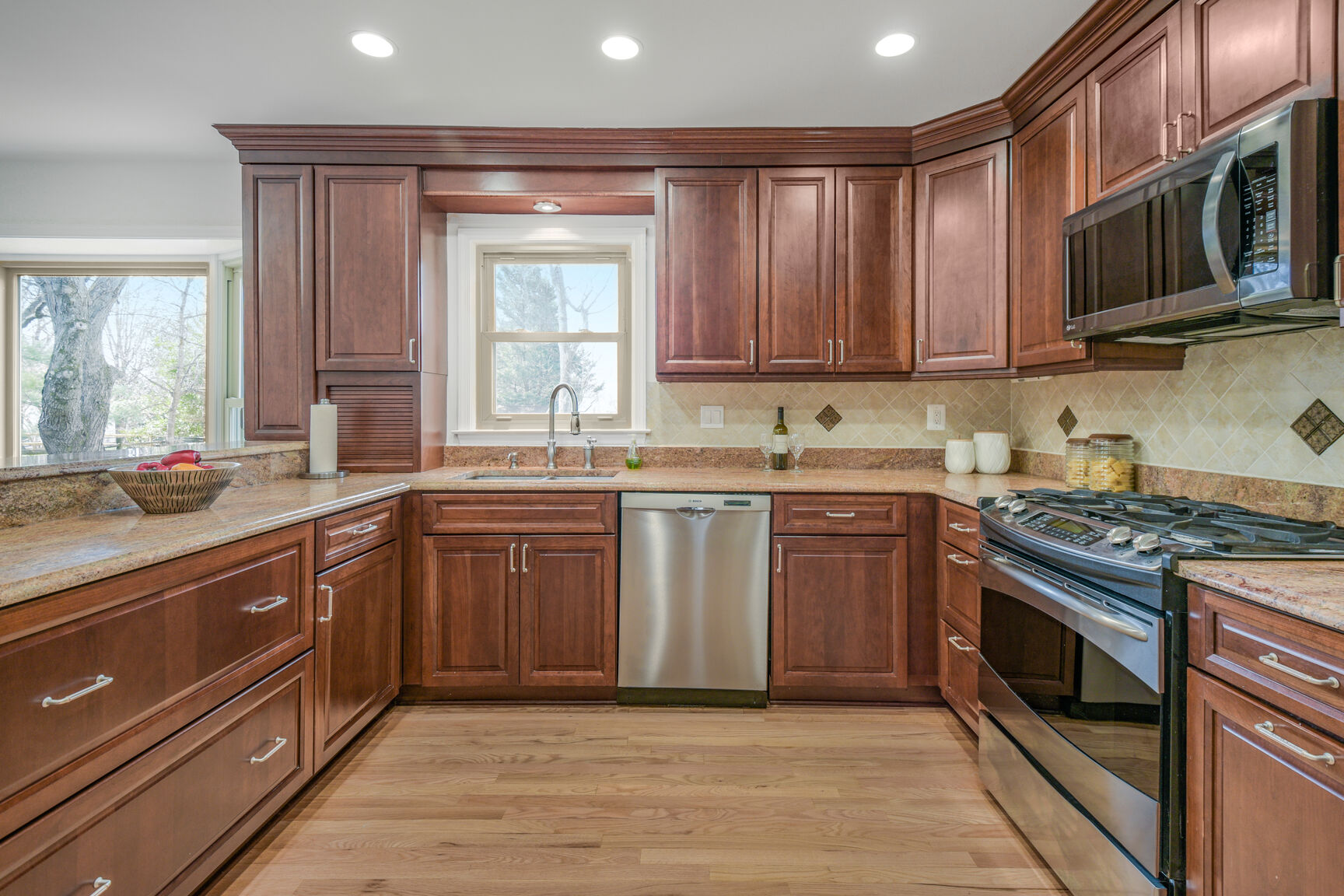 4008 Evangeline Terrace Olney, MD 20832 - Photo 23 of 54 a kitchen with stainless steel appliances granite countertop a stove a sink dishwasher and a microwave oven with large cabinets