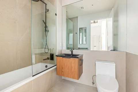 a bathroom with a granite countertop sink a toilet and bathtub