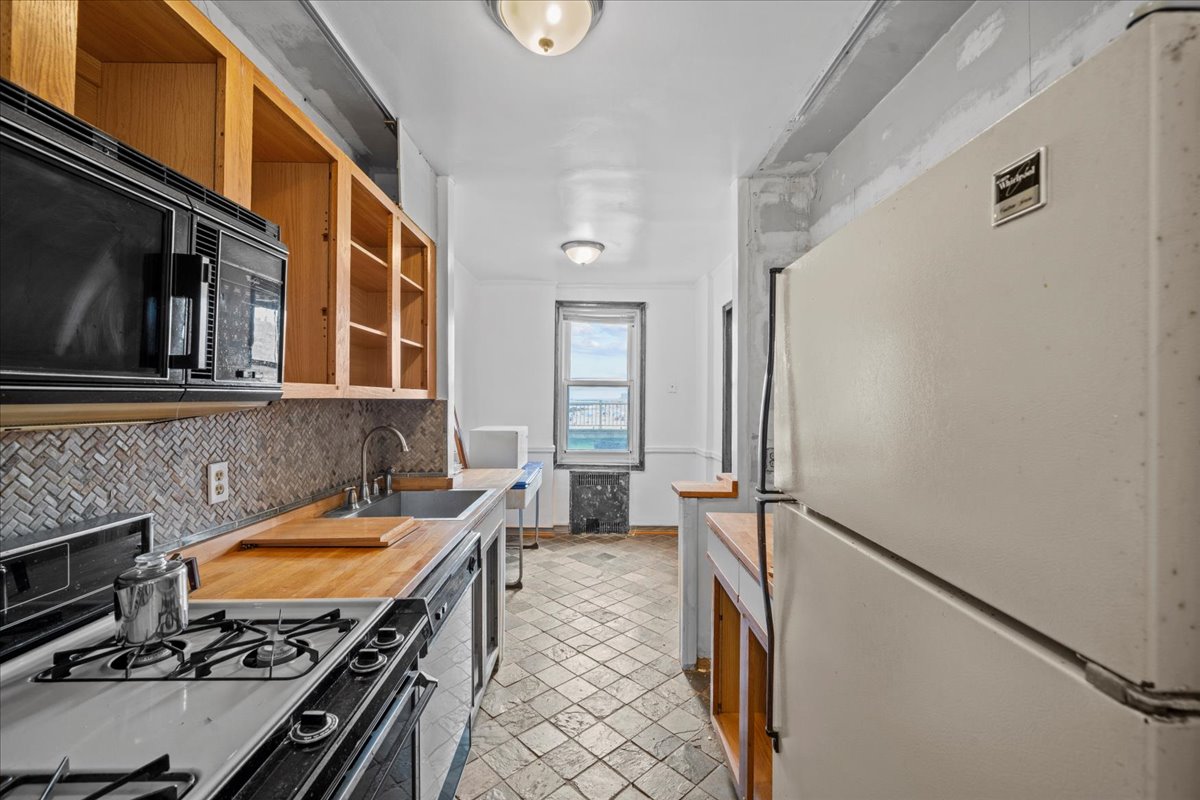 286 Corbin Place, Unit 1D Brooklyn, NY 11235 - Photo 5 of 12 a kitchen with a stove and a refrigerator
