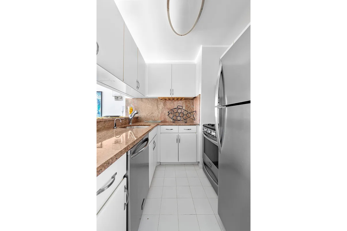 300 East 62nd Street, Unit 1001 Manhattan, NY 10065 - Photo 5 of 10 a kitchen with a sink cabinets and a window