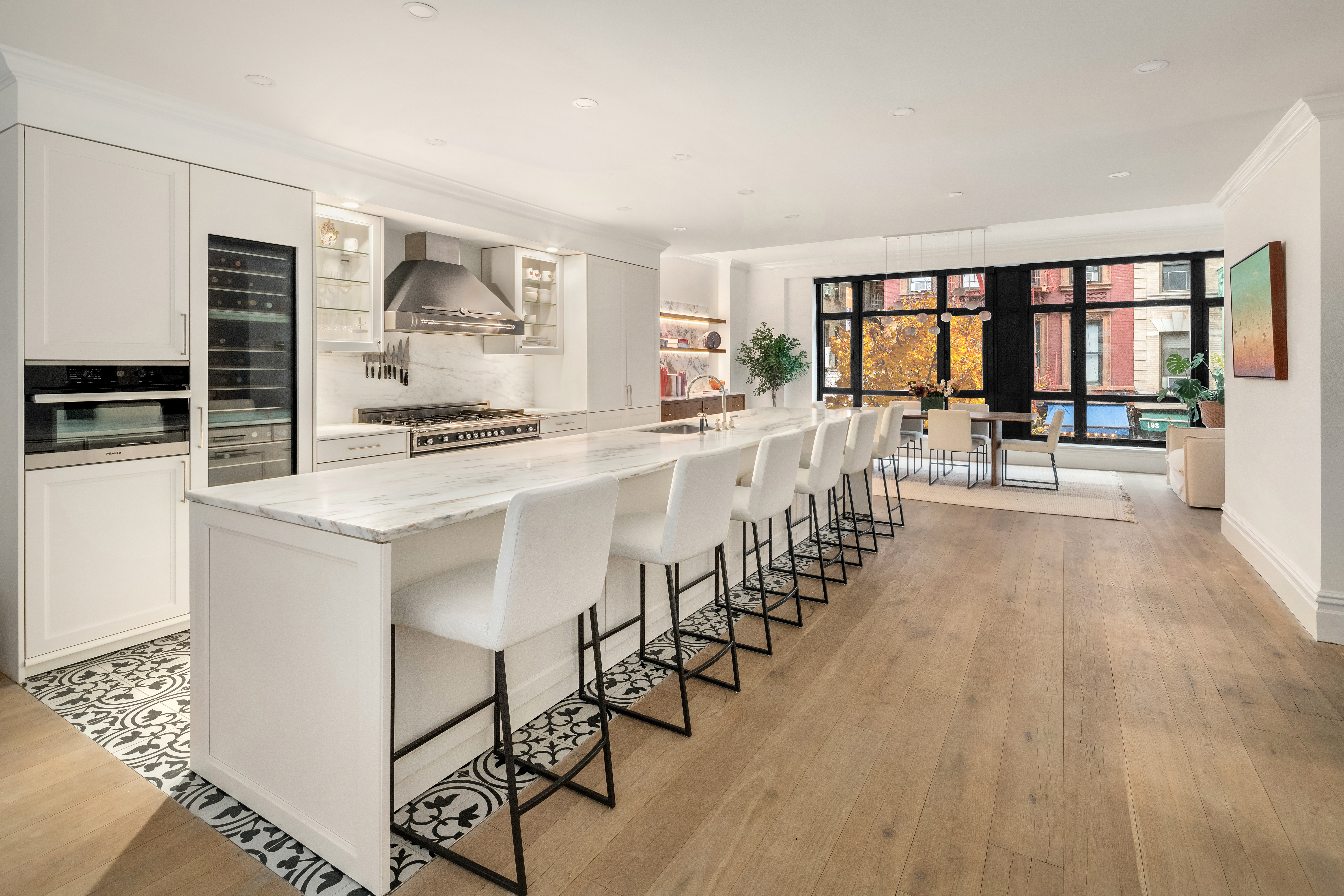 199 Mott Street, Unit 2 Manhattan, NY 10012 - Photo 4 of 14 a large white kitchen with wooden floor and stainless steel appliances