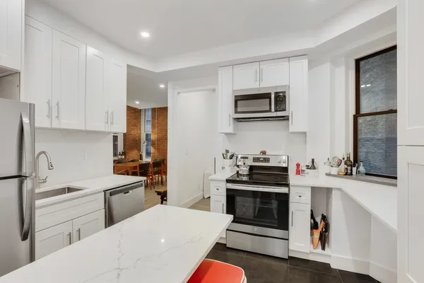 a kitchen with stainless steel appliances a stove sink microwave and cabinets