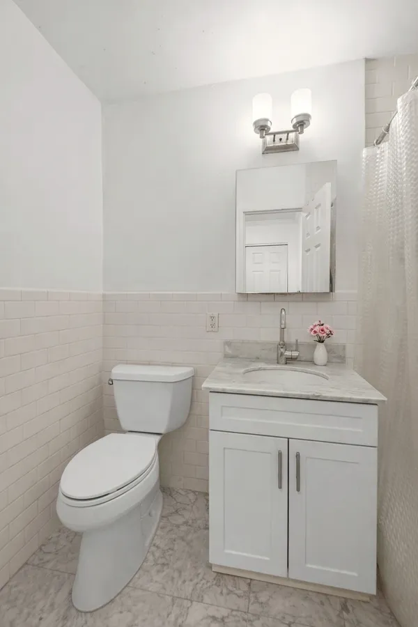a bathroom with a granite countertop toilet sink and mirror