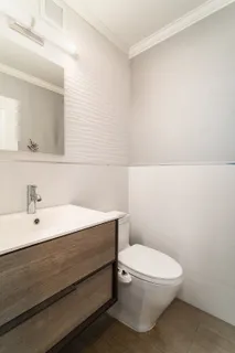 a bathroom with a toilet a sink and mirror