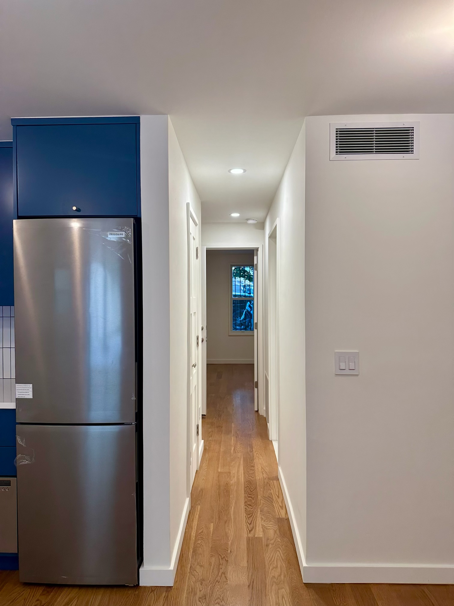 978 Bergen Street, Unit GARDEN Brooklyn, NY 11216 - Photo 12 of 15 a view of a refrigerator in kitchen and an empty room with wooden floor