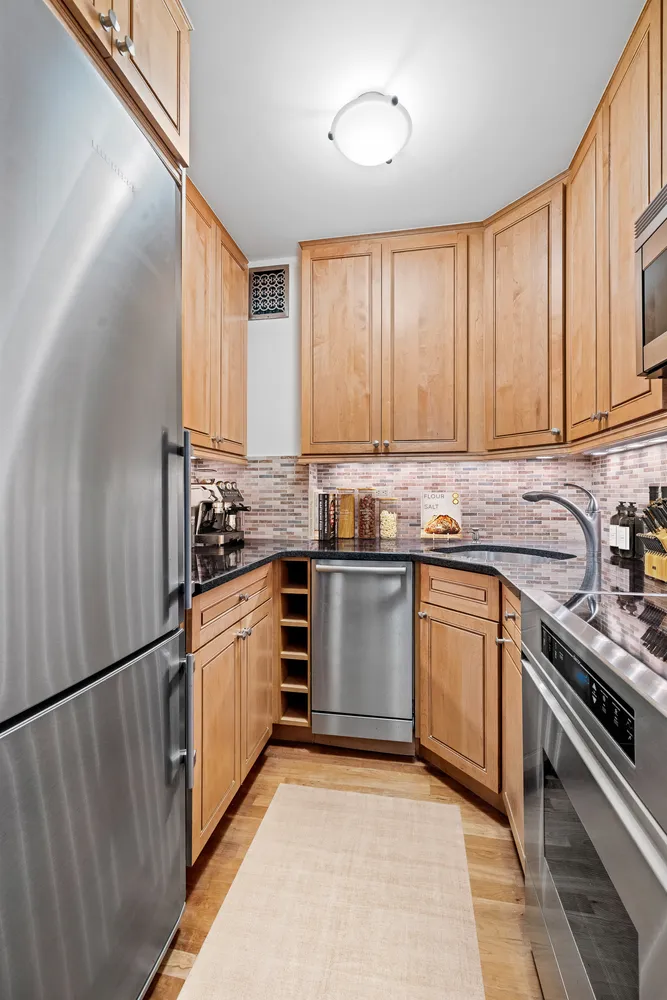 a kitchen with granite countertop stainless steel appliances and cabinets
