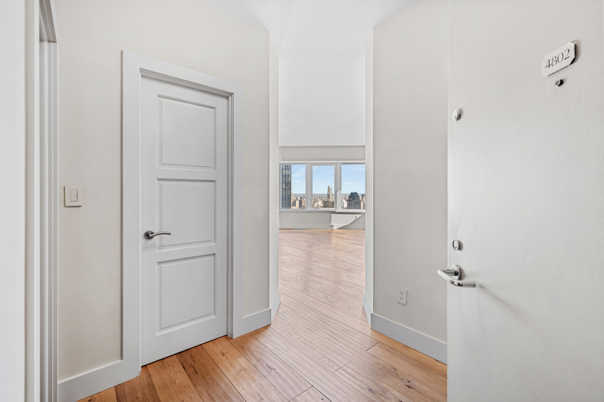 150 West 56th Street, Unit 4802 Manhattan, NY 10019 - Photo 5 of 13 a view of a hallway with wooden floor