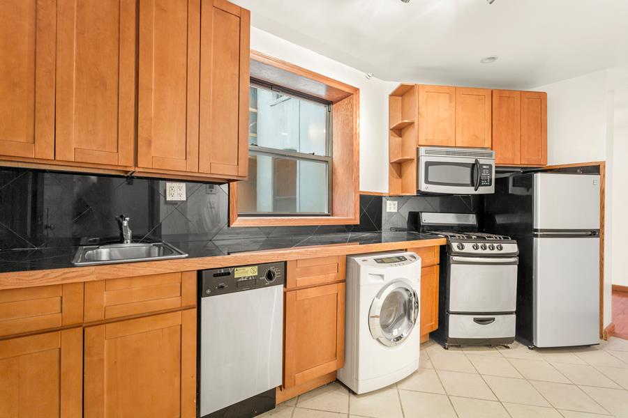 56 MacDougal Street, Unit 16 Manhattan, NY 10012 - Photo 3 of 6 a kitchen with stainless steel appliances granite countertop a refrigerator and a stove top oven