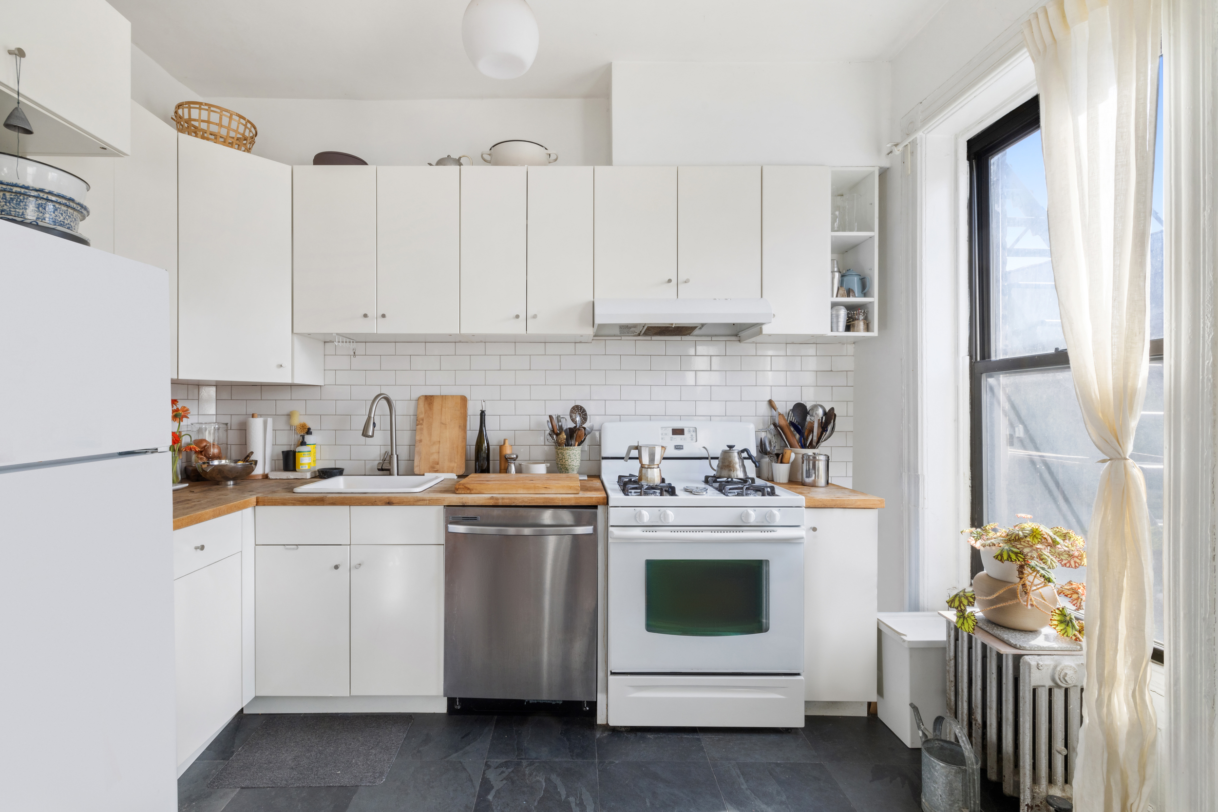 252 Stuyvesant Avenue Brooklyn, NY 11221 - Photo 20 of 26 a kitchen with stainless steel appliances granite countertop a sink and cabinets with wooden floor