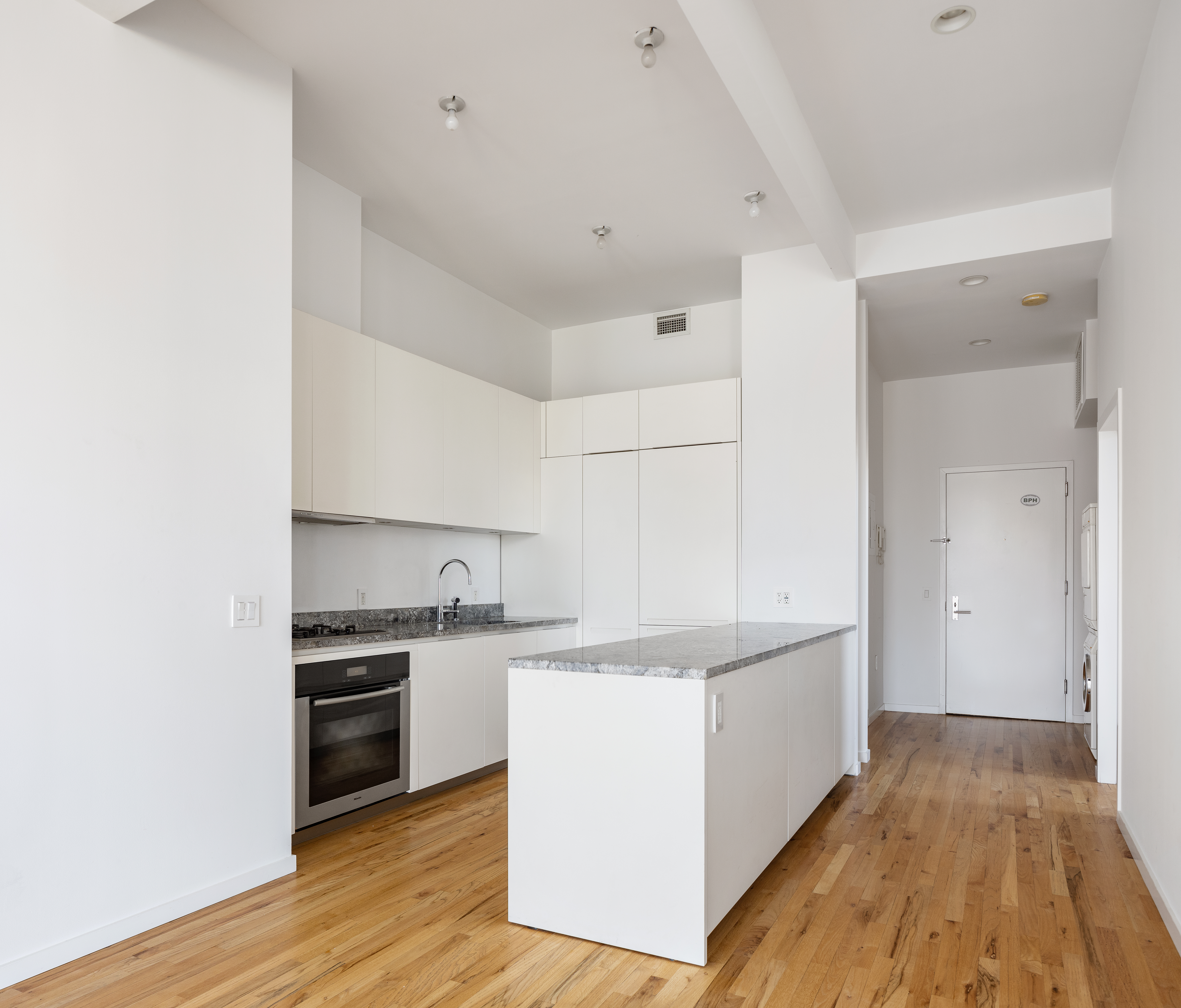 175 East Broadway, Unit 6D Manhattan, NY 10002 - Photo 7 of 18 a kitchen with stainless steel appliances granite countertop a sink and cabinets