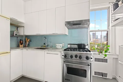 a kitchen with a stove top oven sink and cabinets