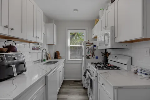a kitchen with a sink stove top oven and cabinets