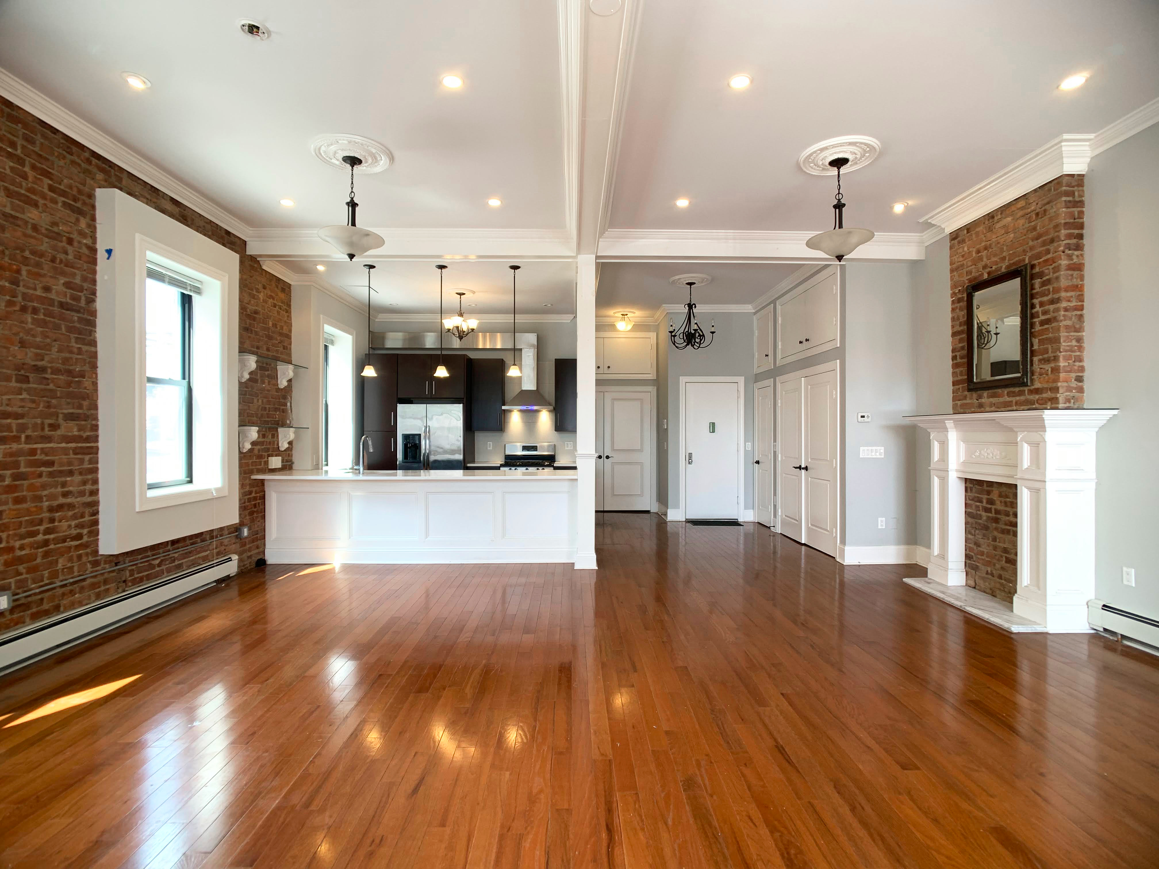 a view of a large kitchen with wooden floors and a fireplace