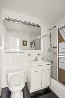a bathroom with a toilet sink shower and mirror
