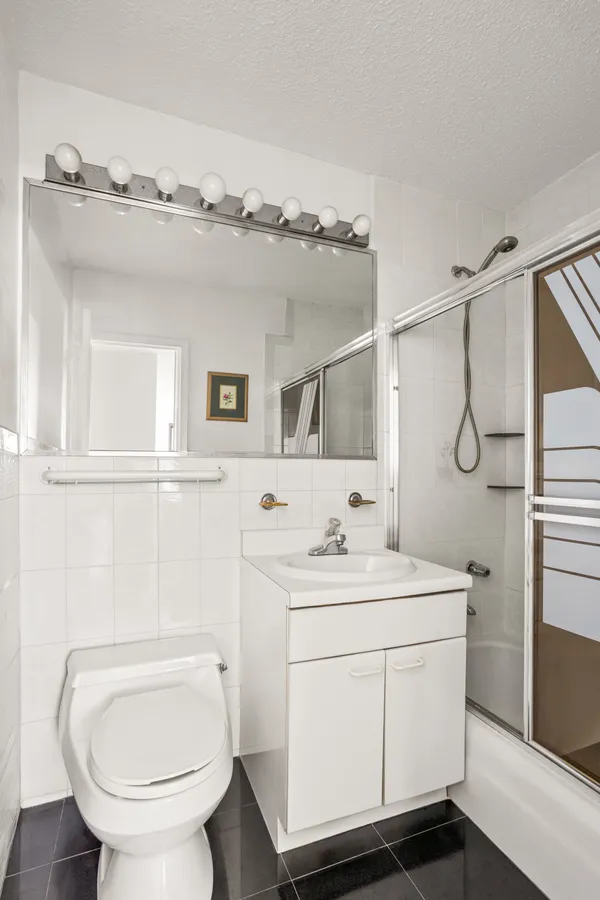 a bathroom with a toilet sink shower and mirror