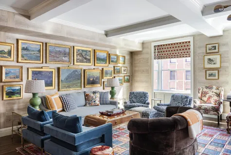 a living room with furniture large windows and wooden floor