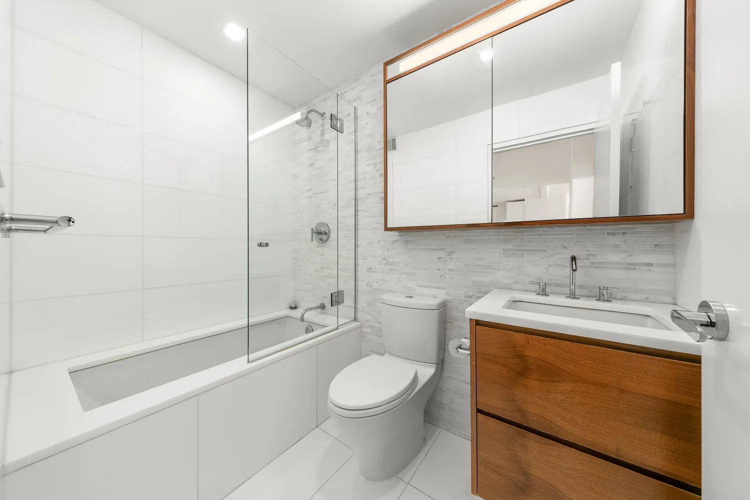 a bathroom with a granite countertop sink toilet a mirror and shower