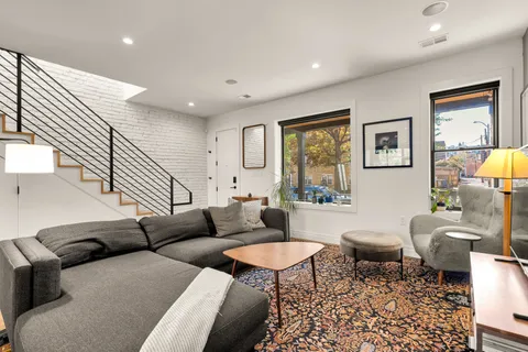 a living room with furniture a rug and a painting on the wall