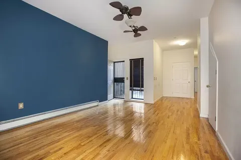 a view of empty room with wooden floor