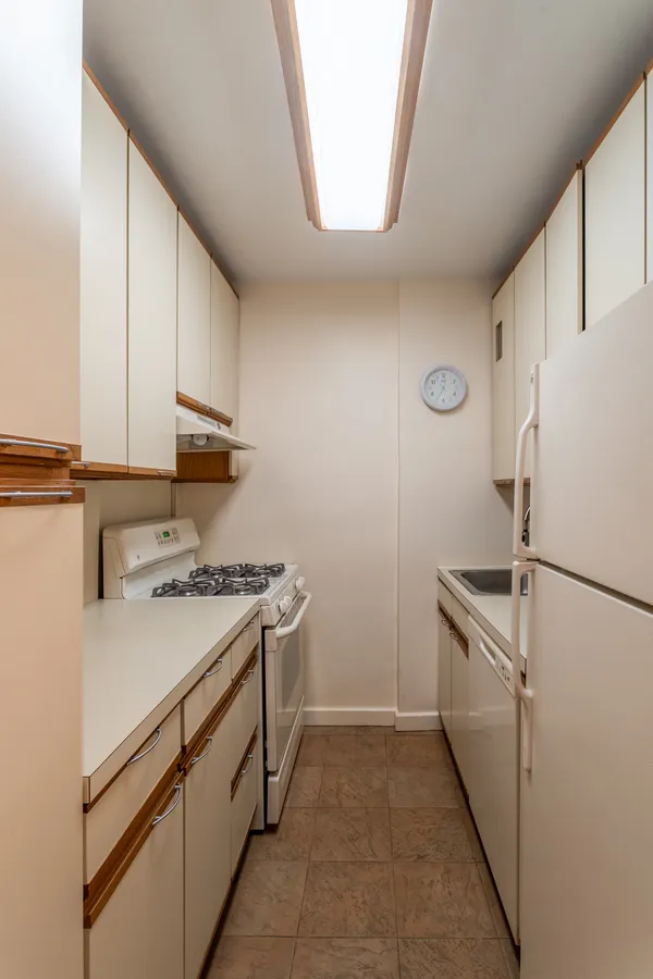 a kitchen with white cabinets and white appliances