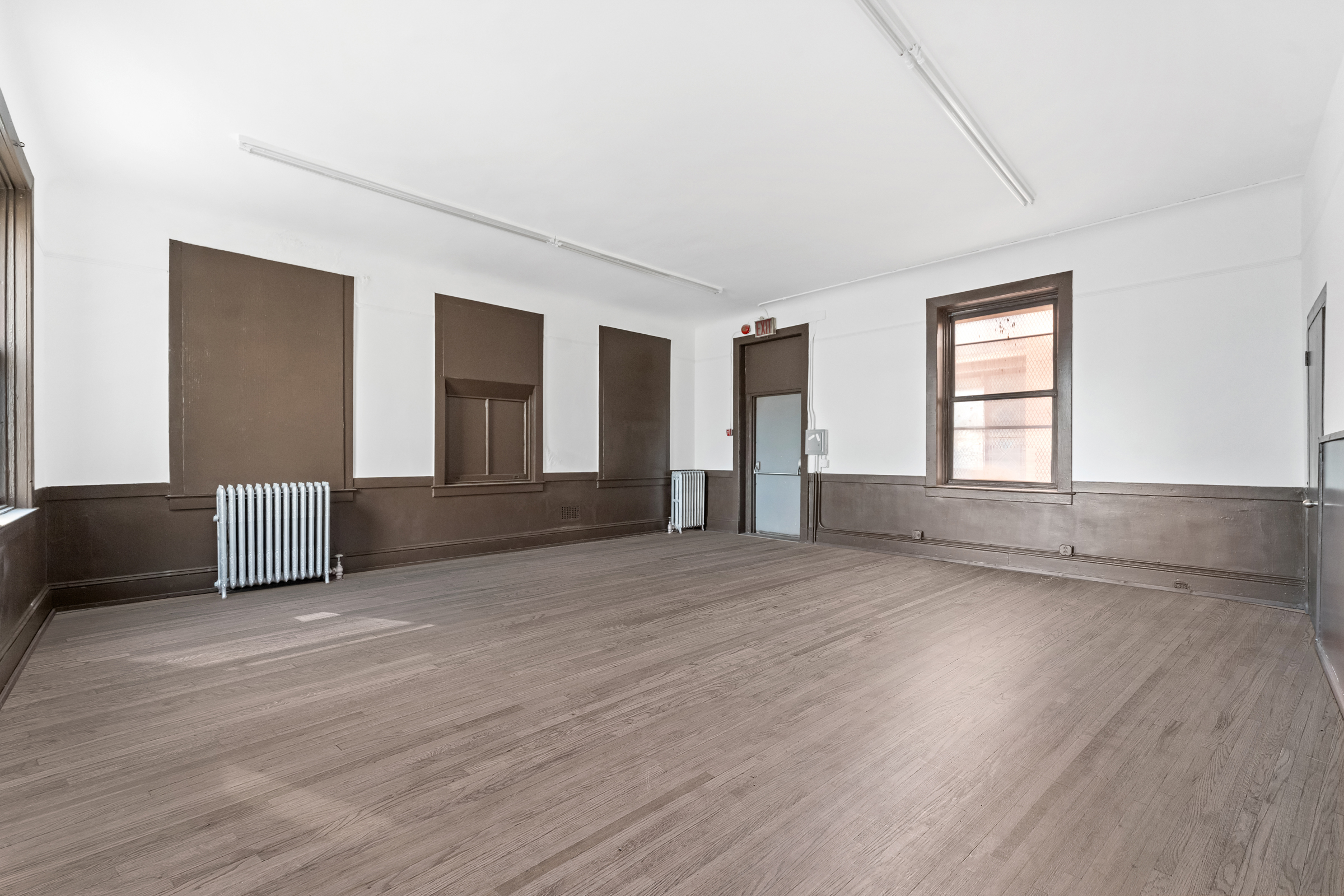 187 Maujer Street Brooklyn, NY 11206 - Photo 3 of 12 a view of an empty room with wooden floor and a window