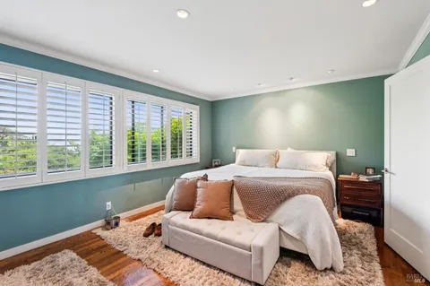a bedroom with a bed and a large window