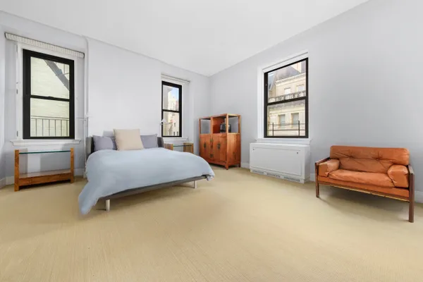 a bedroom with a bed and a couch with window
