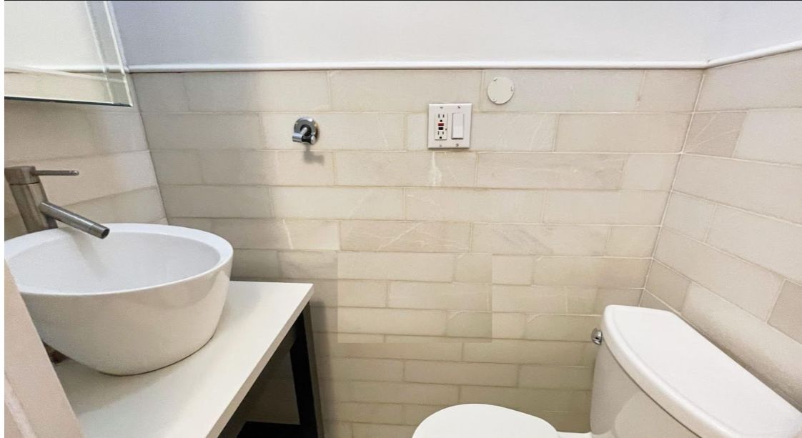 170 Elizabeth Street, Unit 1 Manhattan, NY 10012 - Photo 12 of 16 a bathroom with a sink a toilet and a mirror