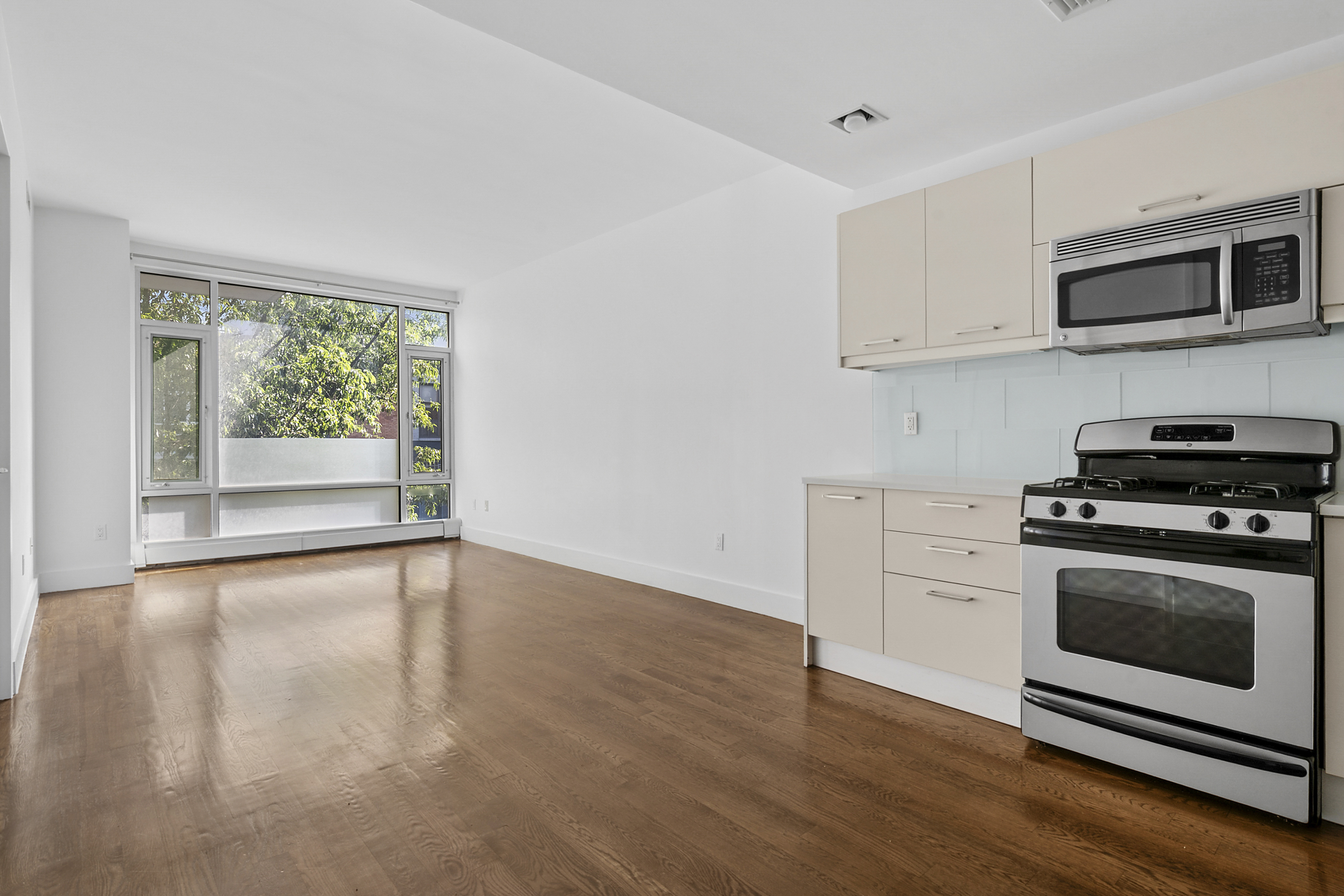 a kitchen with granite countertop a stove a microwave and window