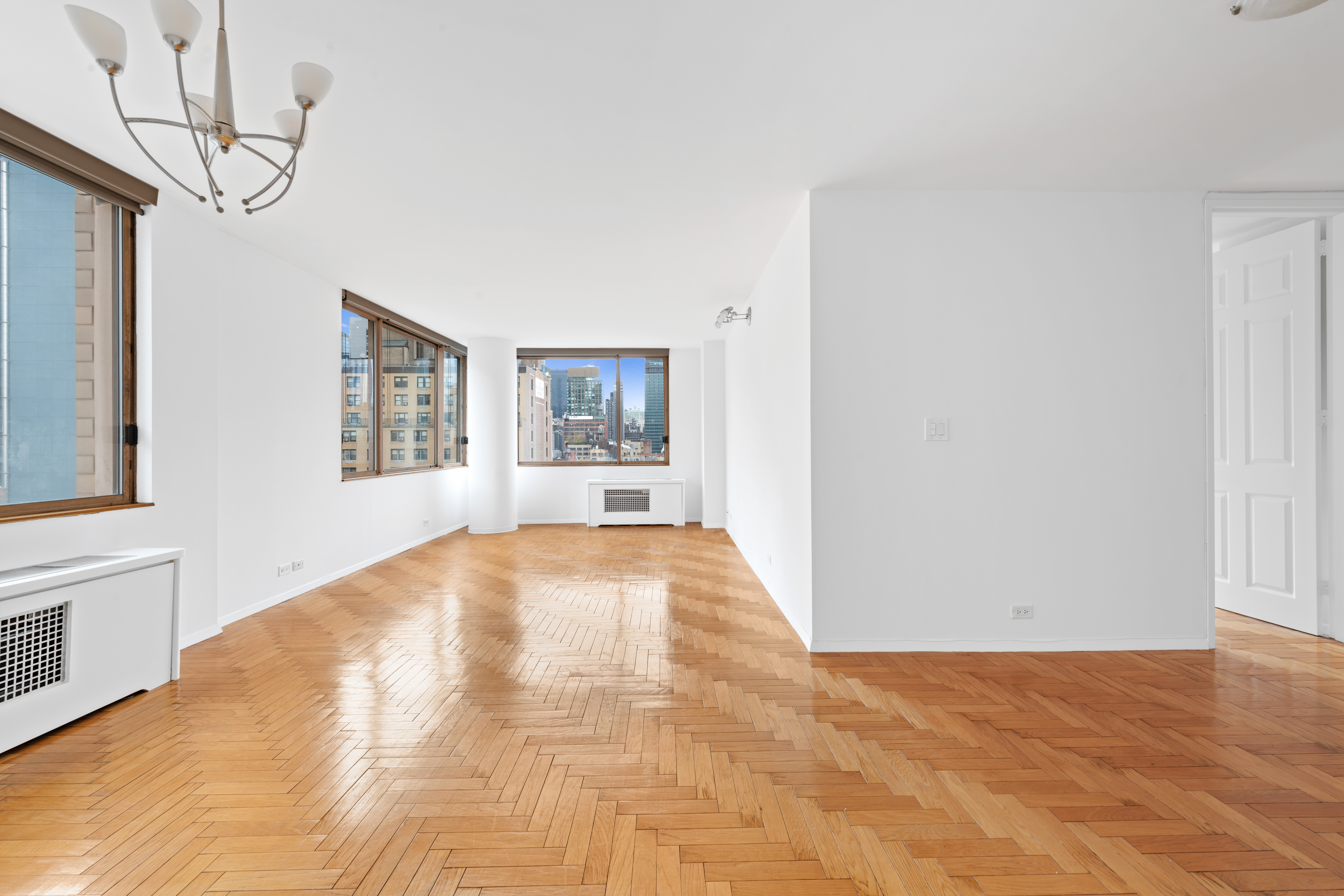 350 West 50th Street, Unit 12B Manhattan, NY 10019 - Photo 2 of 16 a view of empty room with a fireplace and wooden floor