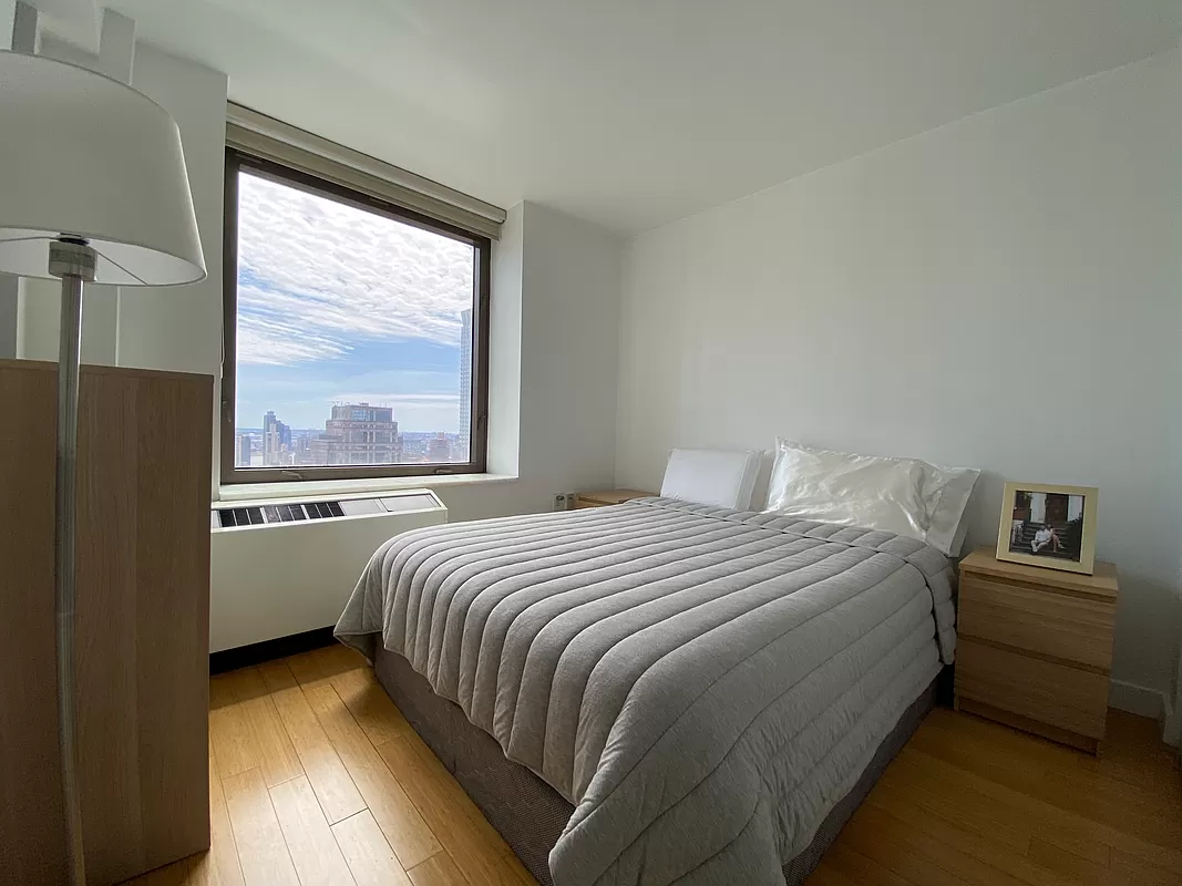 100 West 39th Street, Unit 37E Manhattan, NY 10018 - Photo 3 of 11 a bedroom with a bed and a large window