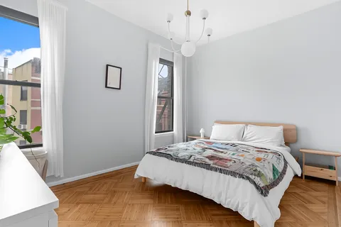 a bedroom with a large bed and a chandelier