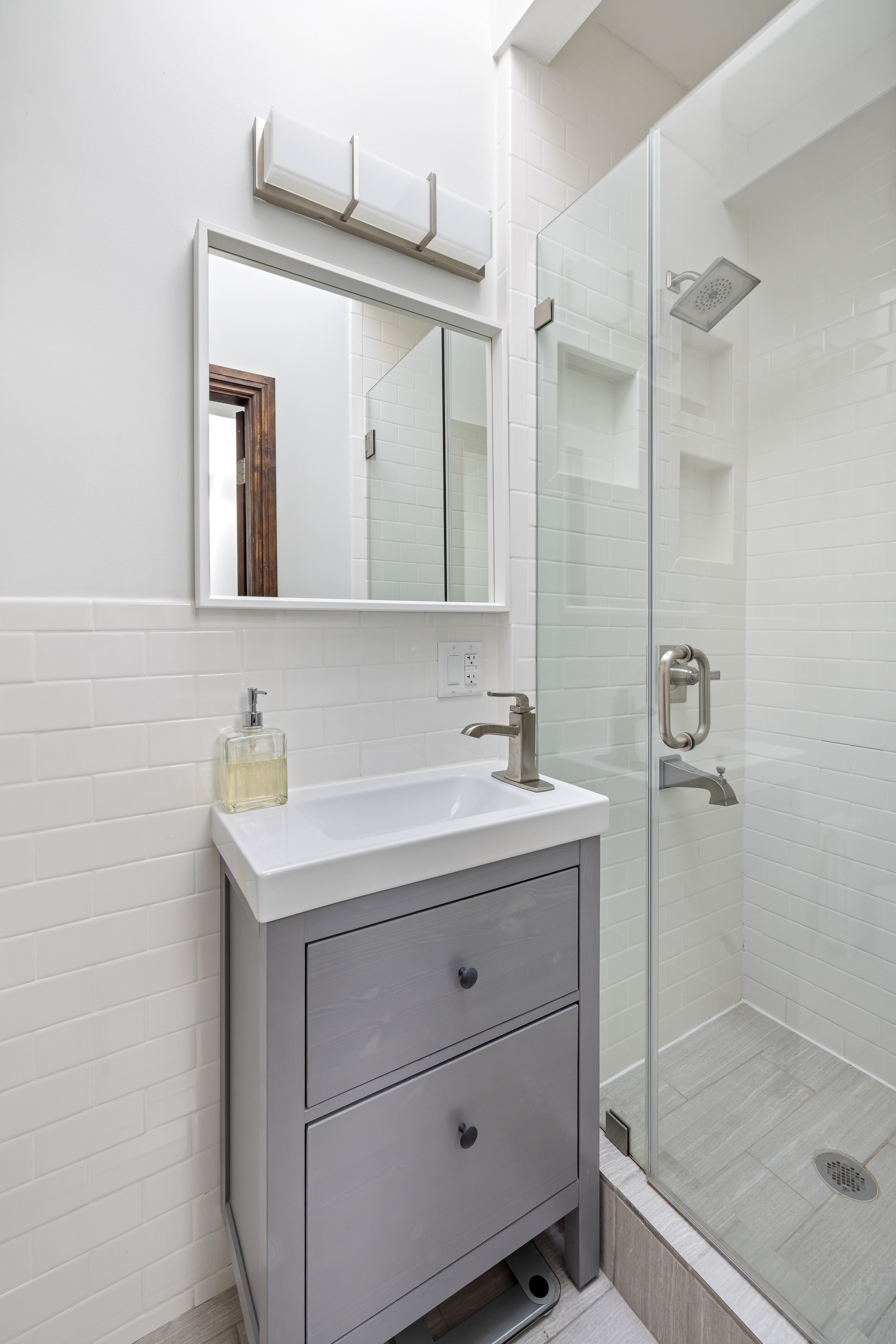 716 Monroe Street Brooklyn, NY 11221 - Photo 11 of 22 a bathroom with a shower sink and mirror