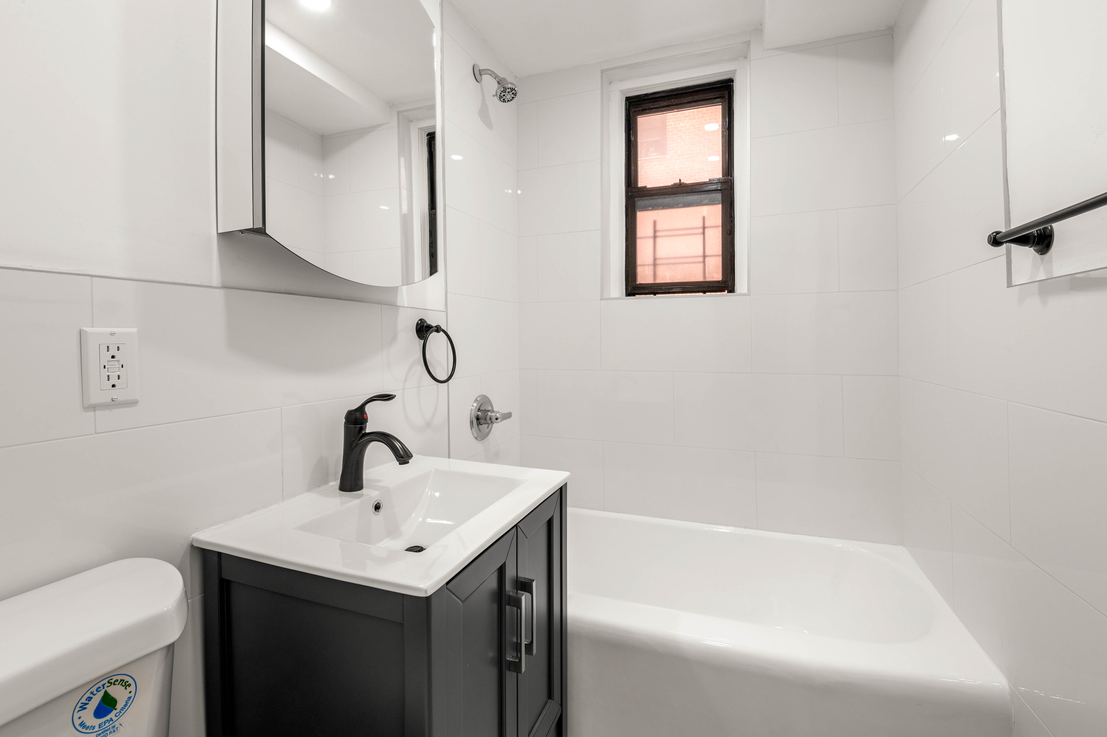 65-15 38th Avenue, Unit 1G Queens, NY 11377 - Photo 7 of 12 a bathroom with a sink and mirror with toilet